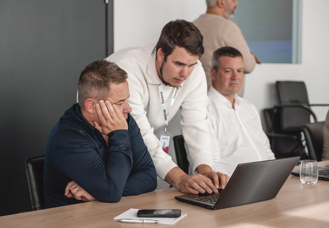 Trois participants examinent ensemble un ordinateur
