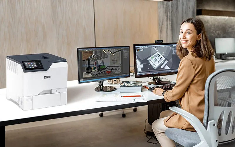 Femme dans un bureau à côté de l'imprimante Xerox® VersaLink® C620