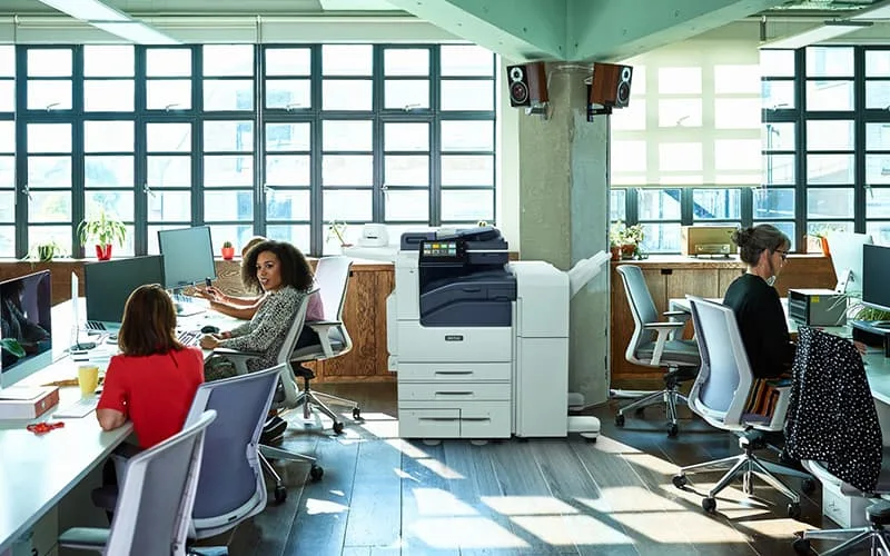 Equipe au travail dans un Open space avec l'imprimante monochrome Xerox® Série VersaLink® B7100